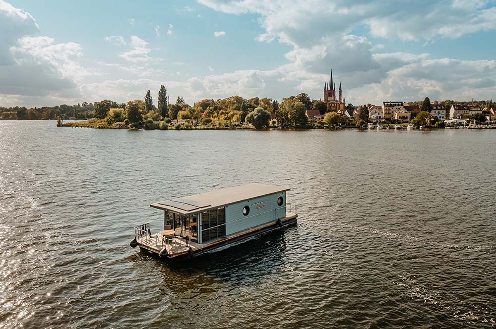 Luftaufnahme eines luxuriösen Hausbootes auf einem der klaren Seen in Brandenburg, ideal für Wasserurlaube.